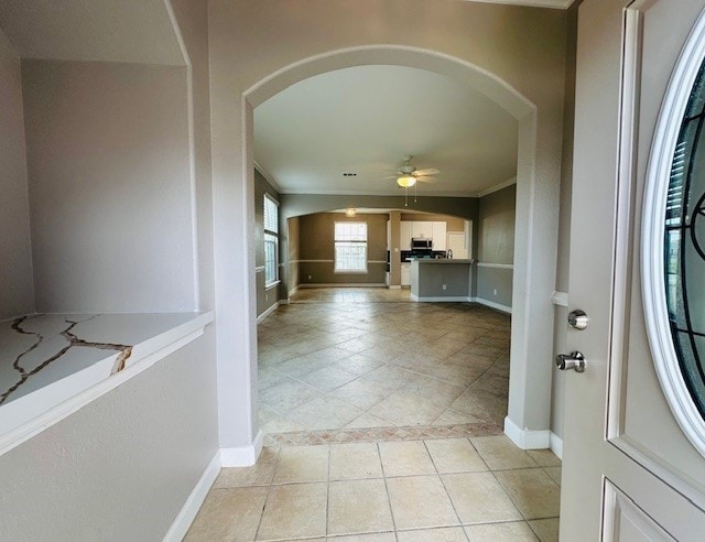 interior space featuring crown molding and light tile patterned floors