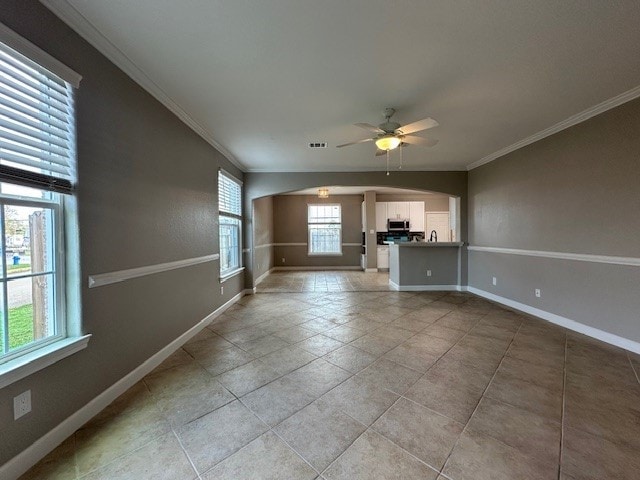 unfurnished living room featuring tile patterned floors, ceiling fan, and ornamental molding