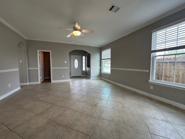 empty room with ceiling fan, crown molding, light tile patterned floors, and a healthy amount of sunlight