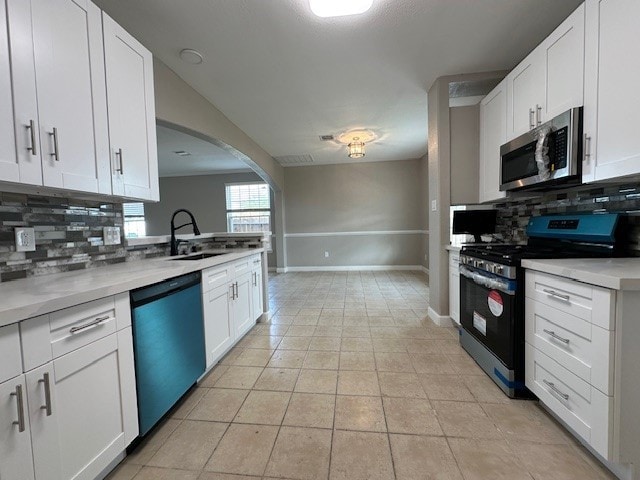 kitchen with sink, white cabinetry, stainless steel appliances, and tasteful backsplash