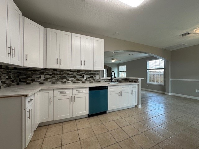 kitchen featuring tasteful backsplash, stainless steel dishwasher, ceiling fan, sink, and white cabinetry