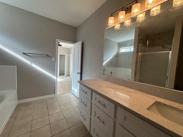 bathroom with tile patterned flooring, vanity, and shower with separate bathtub