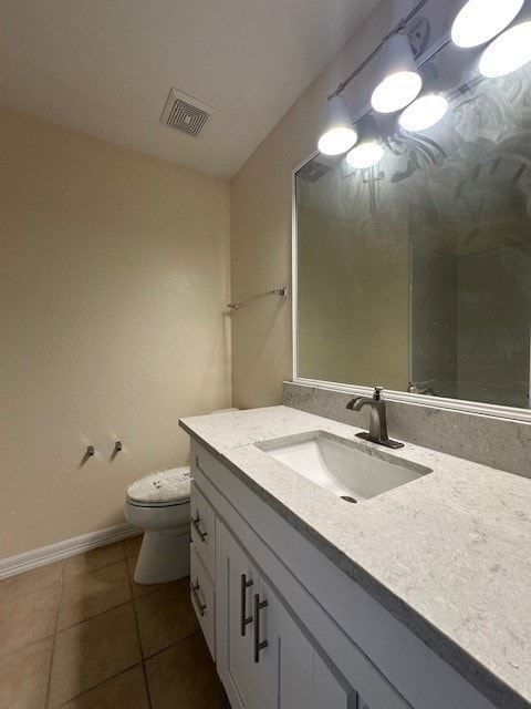 bathroom featuring tile patterned flooring, vanity, and toilet