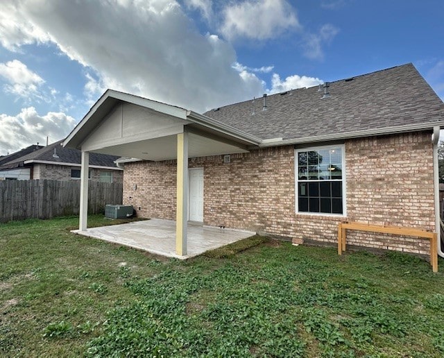 rear view of house featuring a yard and a patio