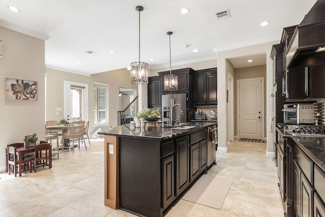 kitchen featuring decorative backsplash, a center island with sink, pendant lighting, and sink