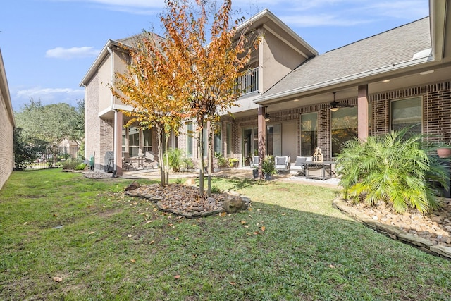 back of property featuring a lawn, a patio area, ceiling fan, and outdoor lounge area