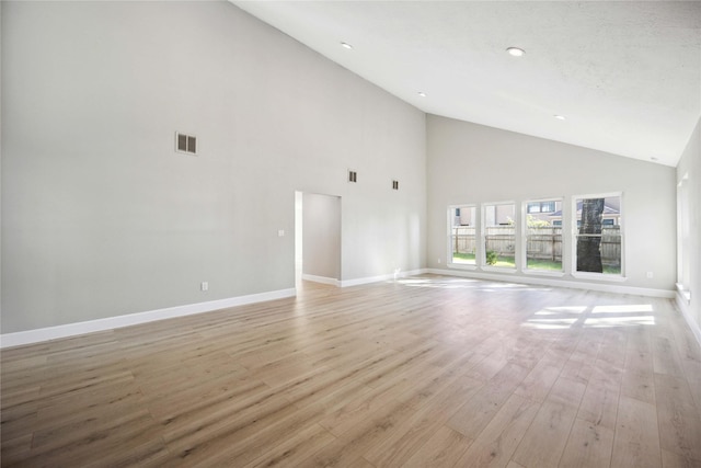 unfurnished living room featuring light wood-type flooring and high vaulted ceiling