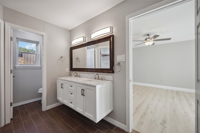 bathroom featuring hardwood / wood-style floors, ceiling fan, toilet, and vanity