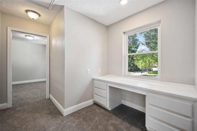 unfurnished office with dark colored carpet and a textured ceiling