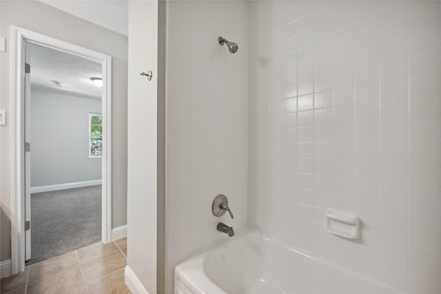 bathroom featuring tile patterned flooring, tiled shower / bath combo, and a textured ceiling