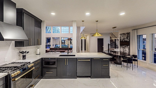 kitchen with sink, wall chimney range hood, kitchen peninsula, pendant lighting, and stainless steel stove