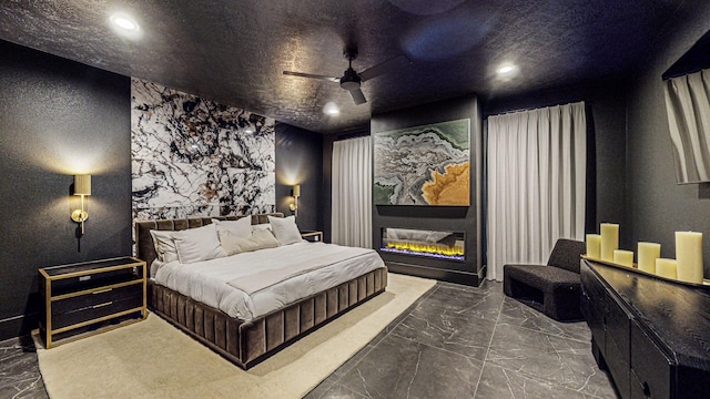 bedroom with ceiling fan and a fireplace