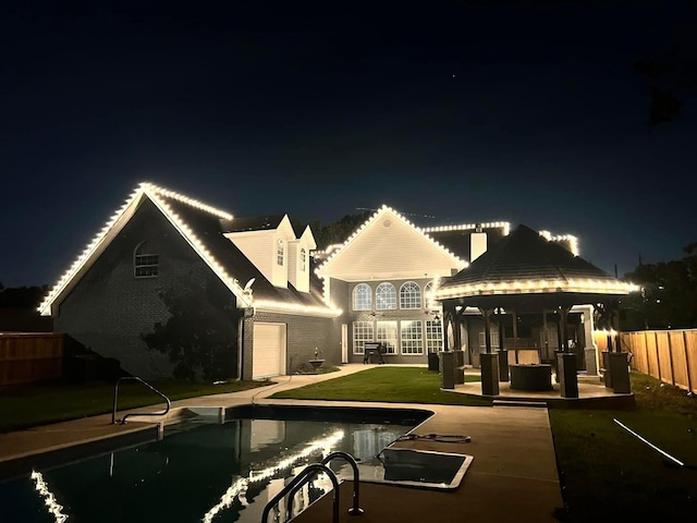 back house at twilight with a fenced in pool, a patio area, an outdoor living space, and a lawn