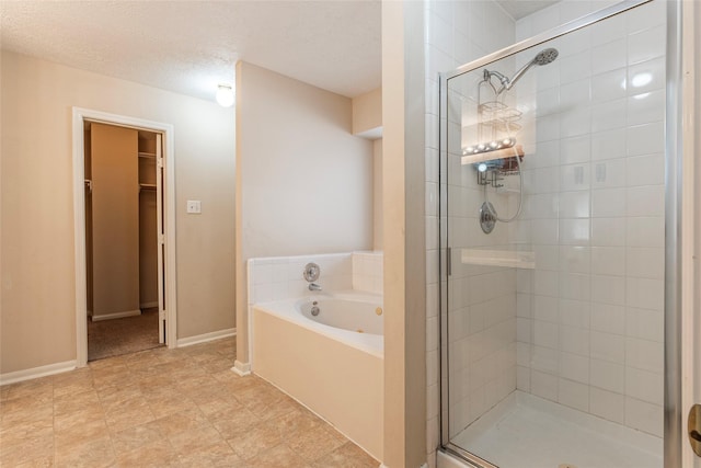 bathroom with a textured ceiling and separate shower and tub