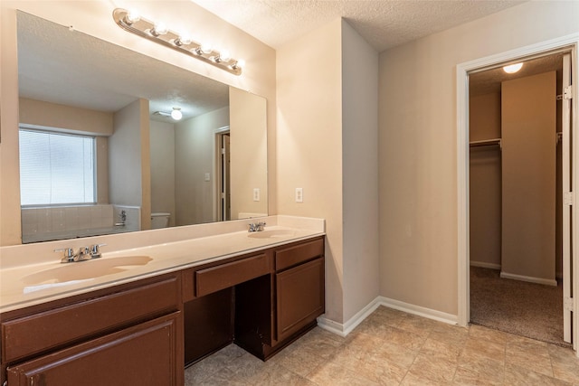 bathroom featuring vanity, a textured ceiling, and toilet