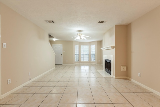 unfurnished living room with light tile patterned floors, a textured ceiling, and ceiling fan