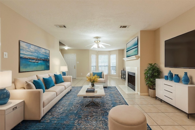 tiled living room featuring a textured ceiling and ceiling fan