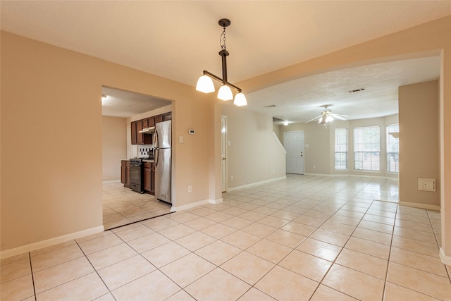 spare room featuring light tile patterned floors, a textured ceiling, and ceiling fan