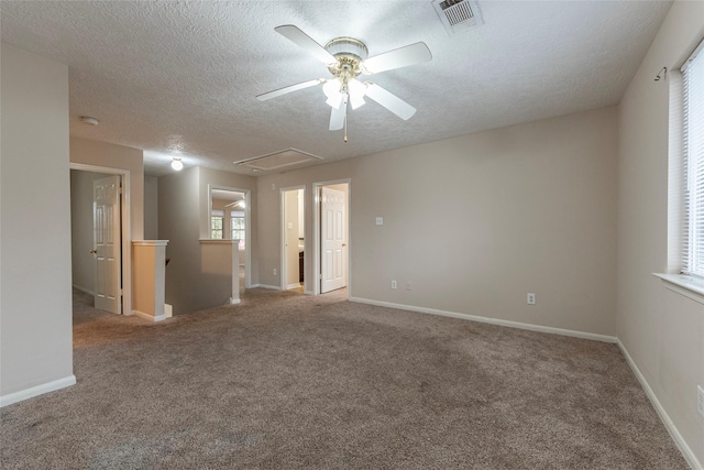 empty room with ceiling fan, carpet floors, and a textured ceiling