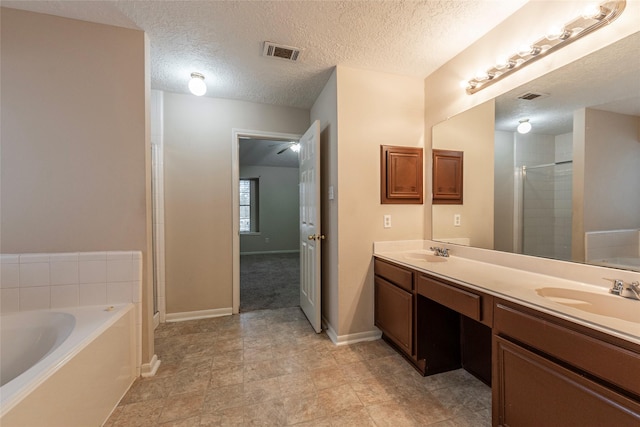 bathroom with vanity, a textured ceiling, and independent shower and bath