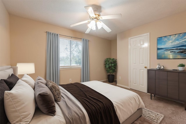 carpeted bedroom featuring ceiling fan and a textured ceiling