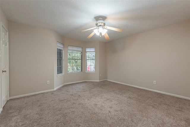 carpeted empty room with ceiling fan and a textured ceiling