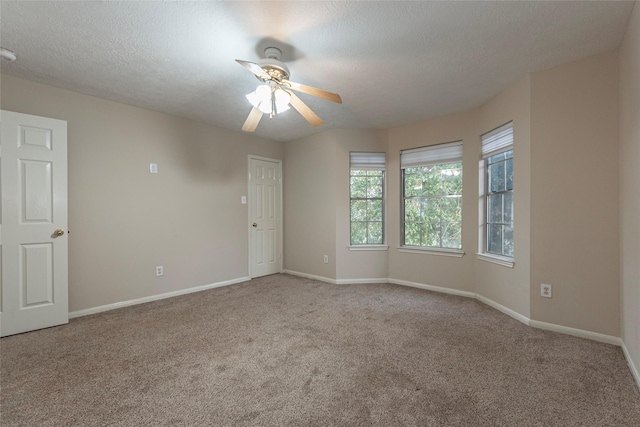 carpeted empty room featuring ceiling fan and a textured ceiling