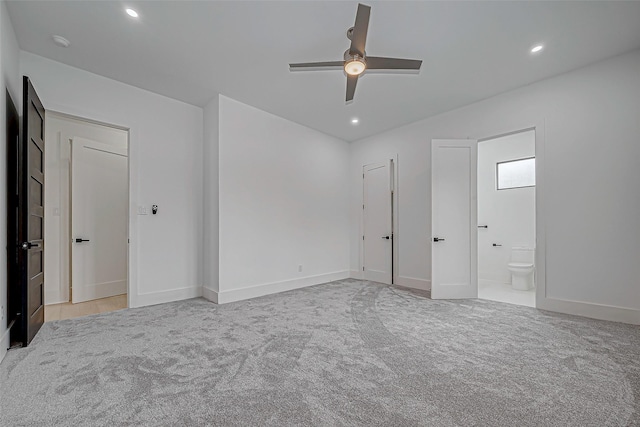 unfurnished bedroom with connected bathroom, ceiling fan, and light carpet