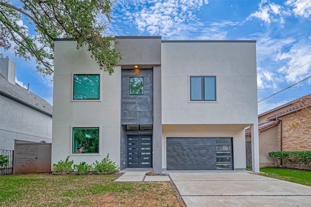 contemporary house featuring a garage and a front lawn