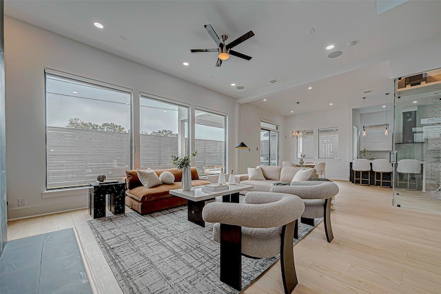 living room with ceiling fan and light hardwood / wood-style flooring