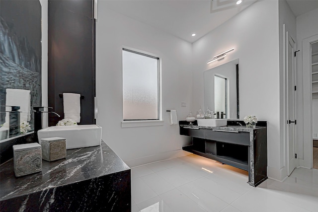 bathroom featuring vanity, a tub to relax in, and tile patterned floors