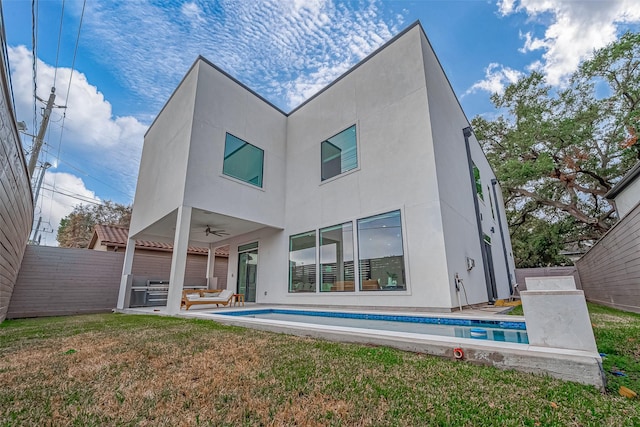 rear view of property with a lawn, ceiling fan, and a patio