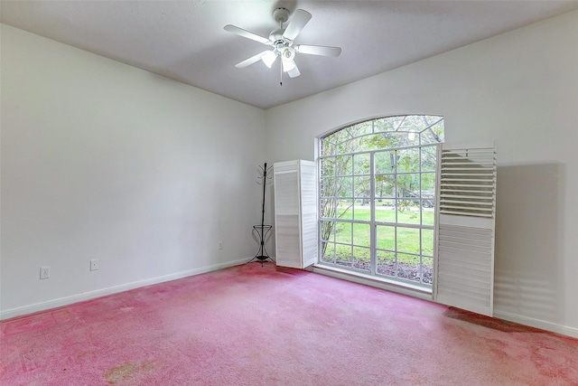 carpeted empty room featuring a wealth of natural light and ceiling fan