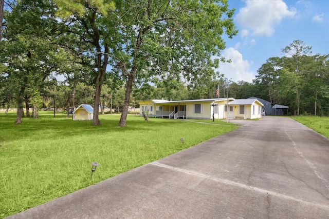 view of front facade with a shed and a front lawn