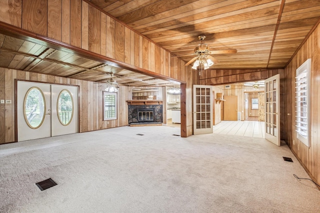 unfurnished living room with wooden walls, carpet floors, wooden ceiling, and vaulted ceiling