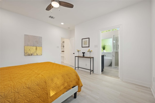 bedroom featuring ceiling fan, ensuite bath, and light hardwood / wood-style flooring