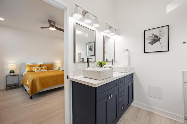 bathroom with hardwood / wood-style flooring, ceiling fan, and vanity