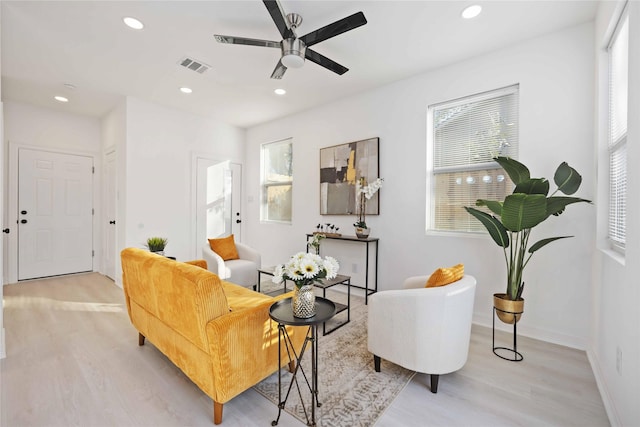 living area with ceiling fan and light hardwood / wood-style flooring