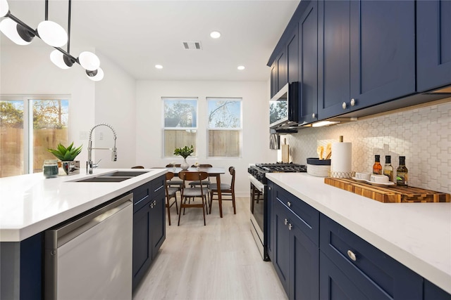 kitchen featuring hanging light fixtures, appliances with stainless steel finishes, sink, and blue cabinetry