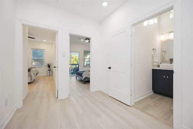 hallway with sink and light wood-type flooring