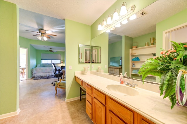 bathroom featuring ceiling fan, vanity, and a textured ceiling