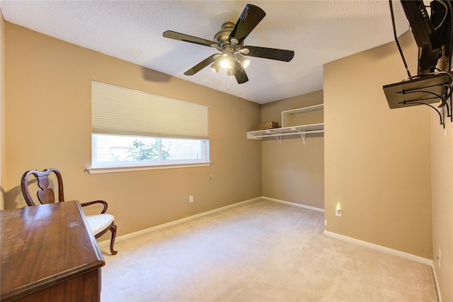 interior space with a textured ceiling, ceiling fan, and light carpet