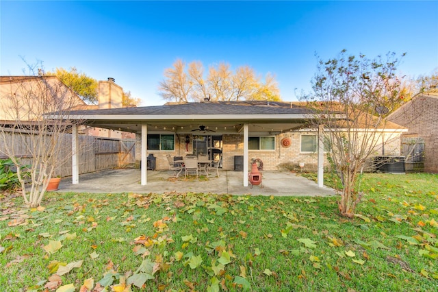 rear view of property with ceiling fan, a yard, and a patio