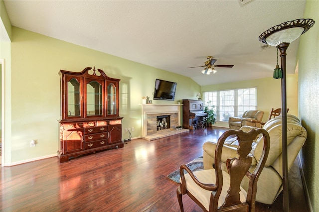 living room with a textured ceiling, ceiling fan, lofted ceiling, and dark wood-type flooring