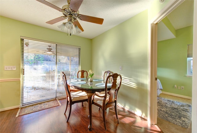 dining space featuring ceiling fan, wood-type flooring, and a textured ceiling