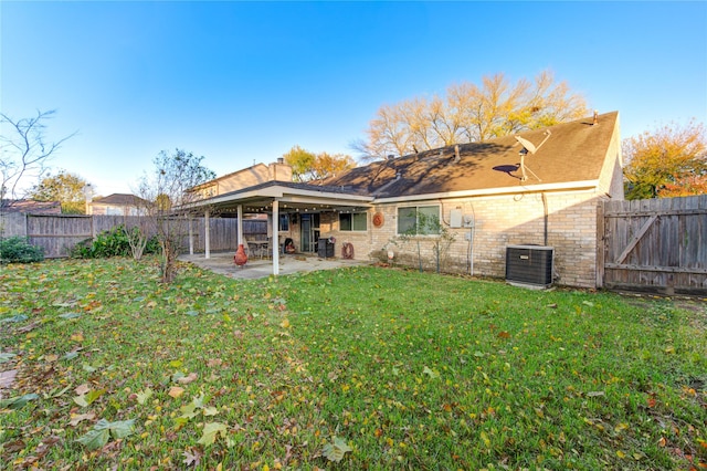 back of property featuring central AC unit, a patio area, and a lawn