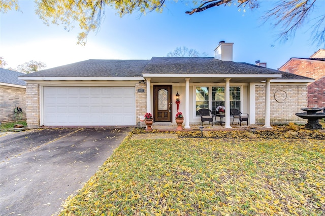 single story home with a front yard, a porch, and a garage