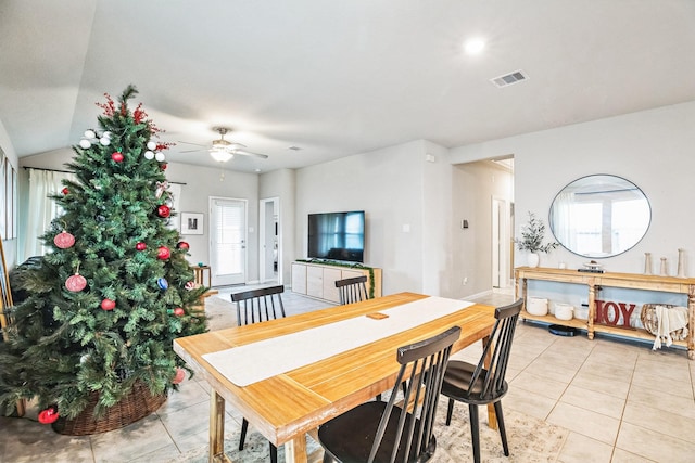 dining room featuring ceiling fan, light tile patterned floors, and lofted ceiling