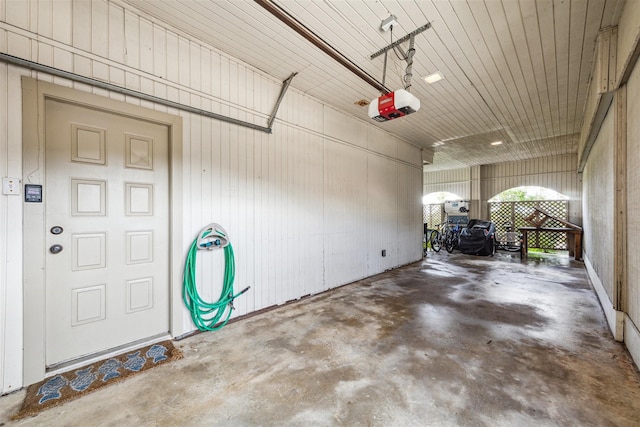 garage with a garage door opener and wooden walls