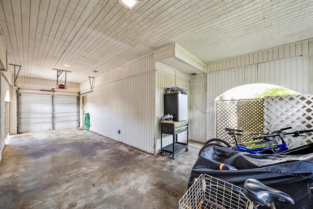 garage featuring wooden walls, a garage door opener, and wooden ceiling